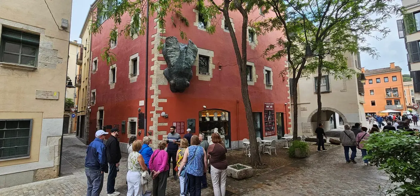 Visitantes ante la Casa de Sant Narcís, con la mosca en la fachada