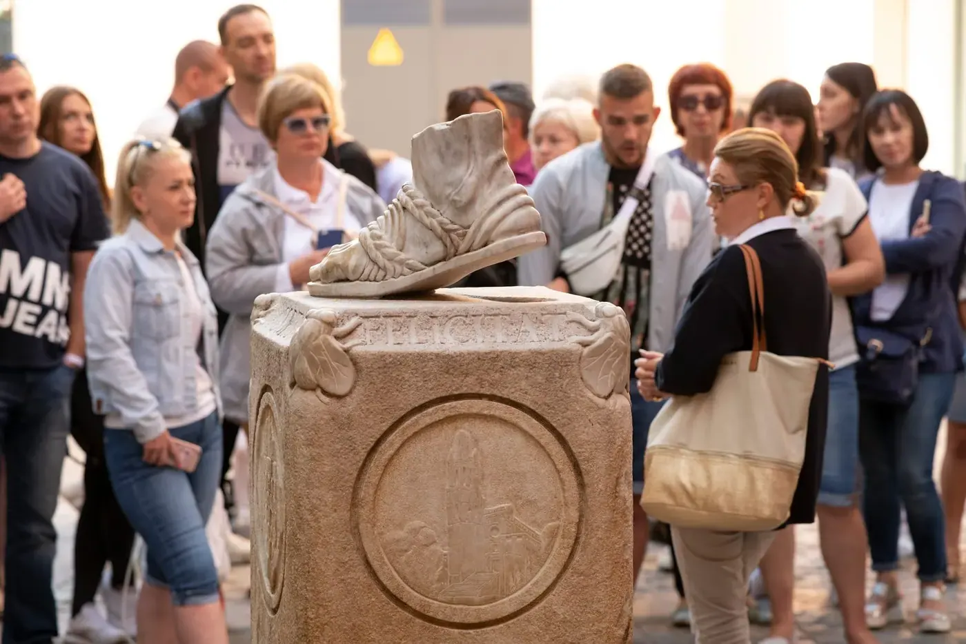 Visitantes tocando la Petjada de Sant Narcís