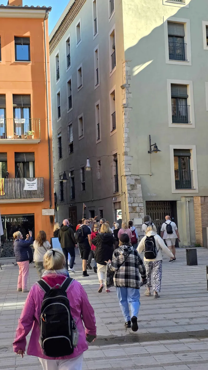 Visitantes en el carrer del Pou Rodó; a la derecha, el edificio del número 22
